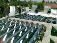 a group of people working on a metal roof