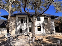 a house under construction with trees in the background