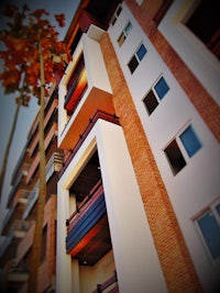 an apartment building with a tree in the background