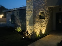 a house is lit up at night with landscape lighting