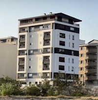 a white and black apartment building near a beach